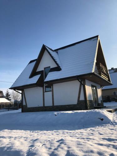 dom ze śniegiem na dachu w obiekcie Domek Góralski Kąty na Wierchu w Szaflarach