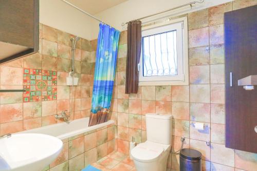 ein Badezimmer mit einem WC, einer Badewanne und einem Waschbecken in der Unterkunft Villa Kristefi in Kato Korakiana