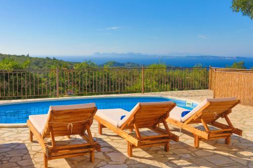 two chairs and a table next to a swimming pool at Vista Mare Isavros in Arvanitakaíïka
