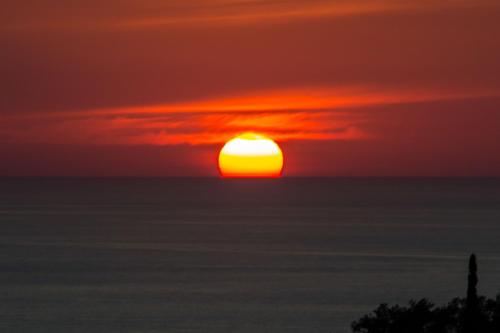 a sunset over the ocean with the sun in the sky at Vista Mare Isavros in Arvanitakaíïka
