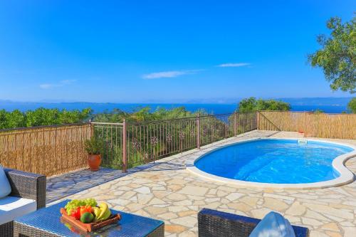 a swimming pool with a bowl of fruit on a table at Vista Mare Isavros in Arvanitakaíïka