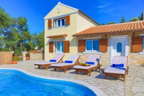 a villa with a swimming pool in front of a house at Vista Mare Isavros in Arvanitakaíïka