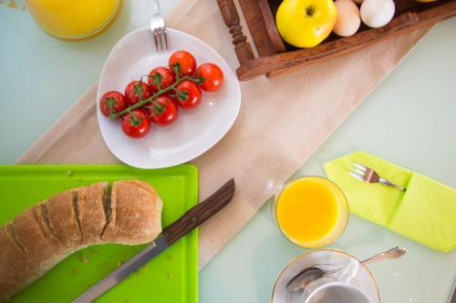 a table with a plate of tomatoes and a plate of bread at Vista Mare Isavros in Arvanitakaíïka