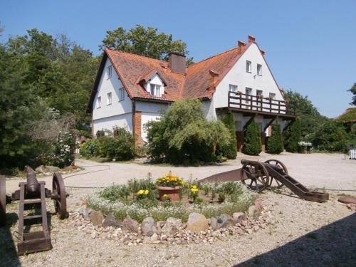 una casa con jardín frente a un parque infantil en Strażnica Komtura, en Mikołajki