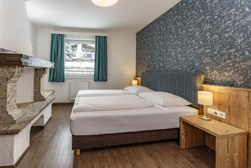 pokój hotelowy z łóżkiem i kominkiem w obiekcie Appartements Landhaus Hubertus Wellness & Breakfast w Schladming