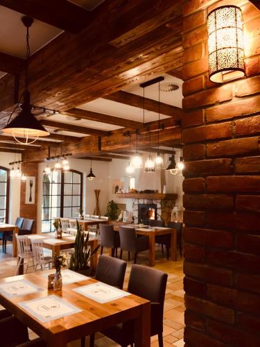 a restaurant with tables and chairs and a brick wall at Hotel Kuźnia Smaków in Małe Pułkowo