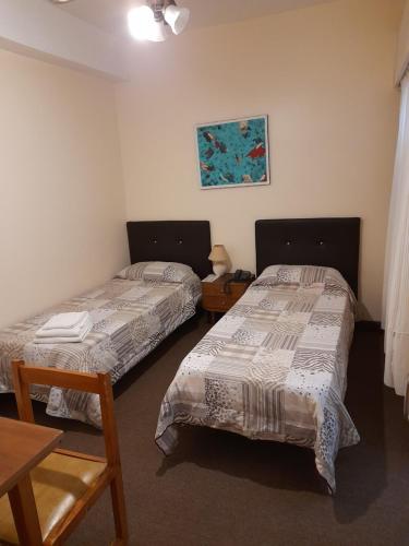 Habitación con 2 camas y mesa. en Hotel Kube en Mar del Plata