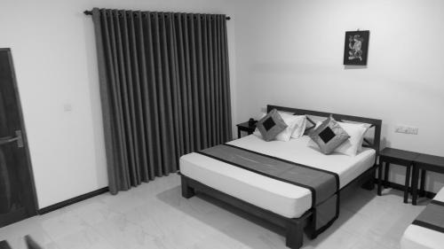 a bedroom with two beds and a window withskirts at Tamarind Tamarind Resort, Tourist Board Approved in Habarana