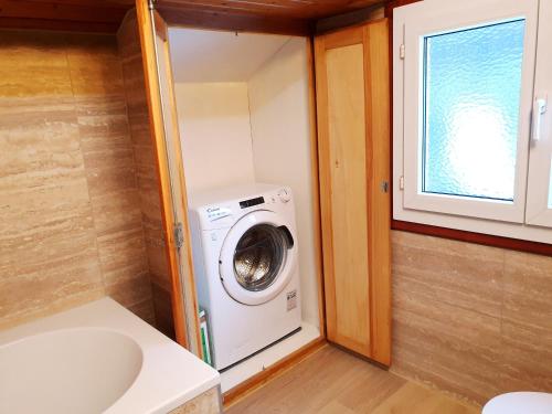 a washer and dryer in a small bathroom at Accogliente mansarda in Grono