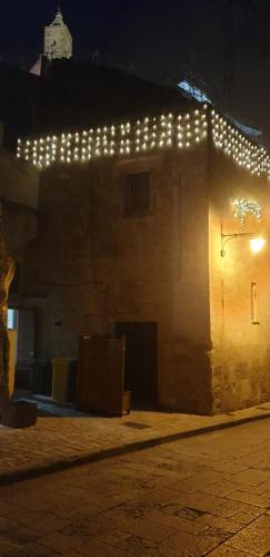 a building with lights on the side of it at night at Sassi e Virtù in Matera