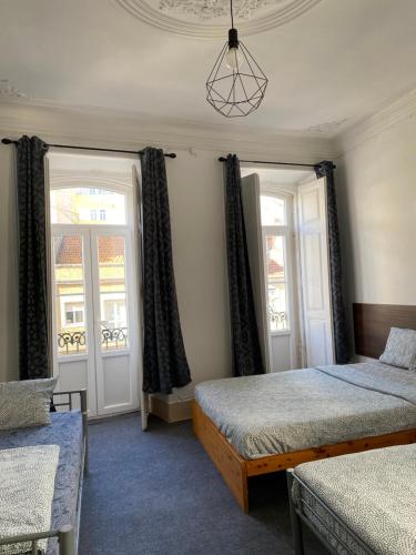 a bedroom with two beds and two windows at Sri-Indo Guest House in Lisbon