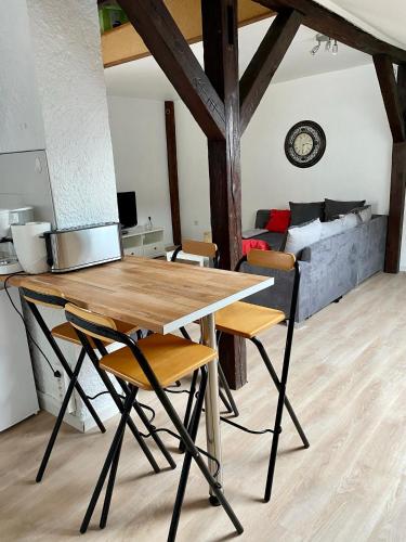 - une table et des chaises dans une chambre avec un canapé dans l'établissement Authentic Loft - 10 min to the city center, à Schiltigheim