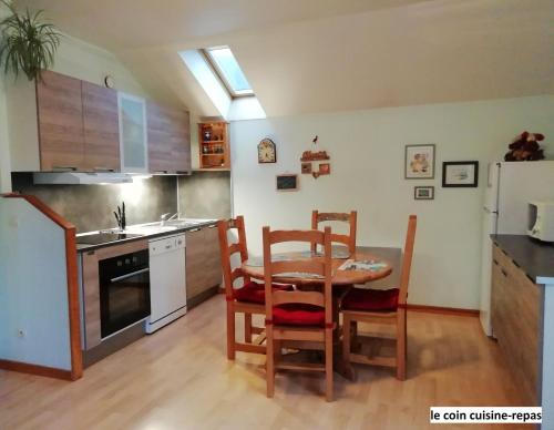 a kitchen with a table and chairs and a refrigerator at Le Chalet Bel Air in Oderen