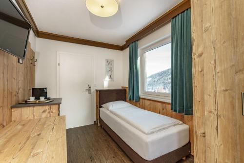 Kleines Zimmer mit einem Bett und einem Fenster in der Unterkunft Landhaus Hubertus in Schladming