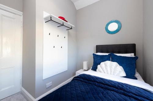 a bedroom with a blue and white bed and a mirror at Stylish George Street Apartment in Peebles