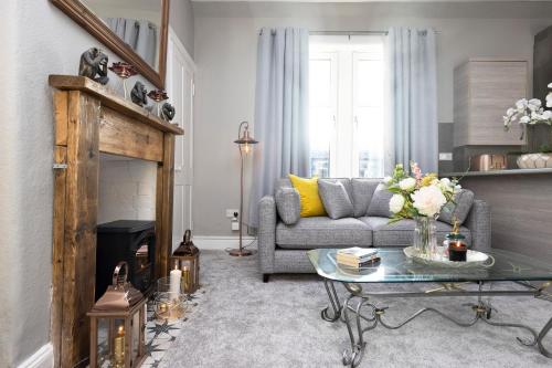 a living room with a couch and a table at Stylish George Street Apartment in Peebles