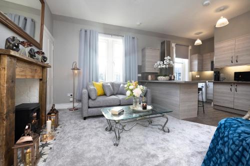 a living room with a couch and a table at Stylish George Street Apartment in Peebles