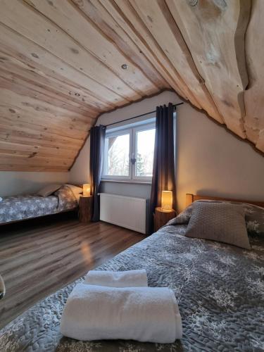 a bedroom with a large bed and a wooden ceiling at Domek Drwala k. Karpacza in Sosnówka