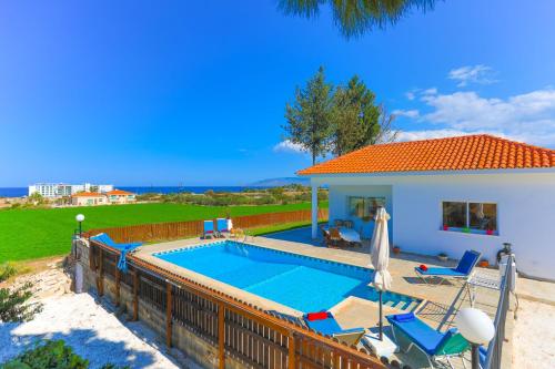 a swimming pool with chairs and a house at The Vines in Lachi