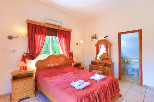Schlafzimmer mit einem roten Bett und einem Spiegel in der Unterkunft The Vines in Lachi