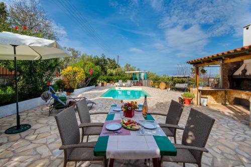 a patio with a table and chairs and a pool at Villa Yiotta in (( Kalodhikátika ))