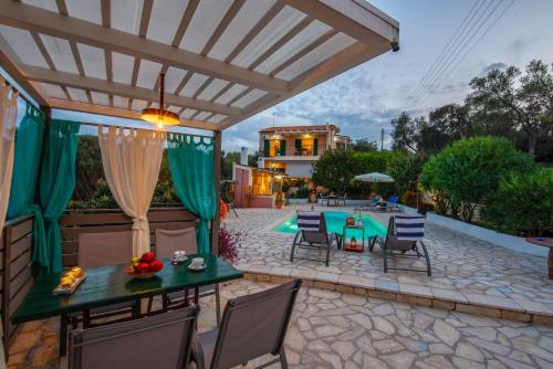 a patio with a table and chairs and a pool at Villa Yiotta in (( Kalodhikátika ))
