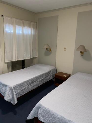 a hotel room with two beds and a window at Hotel Miami in San Miguel de Tucumán