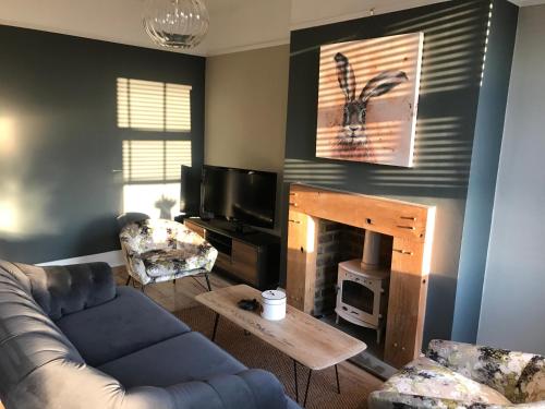 a living room with a couch and a fireplace at Heather Bank Cottage, Halifax. Yorkshire. HX2 7DD in Halifax