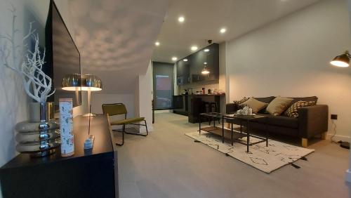 uma sala de estar com um sofá e uma mesa em Apartamento Golddem Mercedes. em Málaga