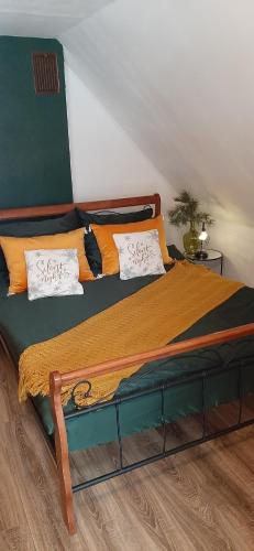 - une chambre dotée d'un grand lit avec des draps orange et verts dans l'établissement Nad Potokiem, à Grąziowa