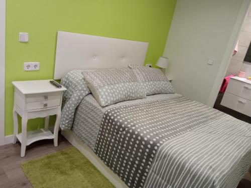 a small bedroom with a bed and a night stand at VIVE CENTRO ASTORGA in Astorga