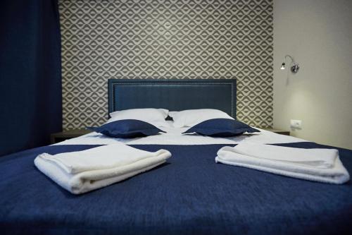 a blue bed with towels on top of it at Vila Iris in Chişinău