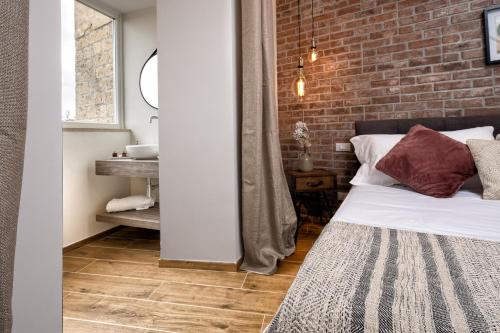 a bedroom with a brick wall and a bed at Casa Checca e Casa Maria appartamenti per vacanze in Caprarola