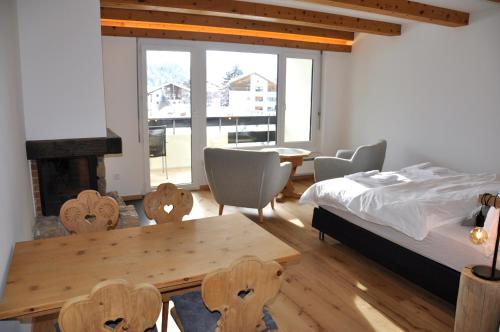 a bedroom with a bed and a table and chairs at Charming Studio facing Piz Rosatsch in St. Moritz
