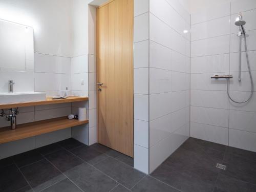 La salle de bains est pourvue d'une douche et d'un lavabo. dans l'établissement Ferienwohnung z'übrmello, à Mellau