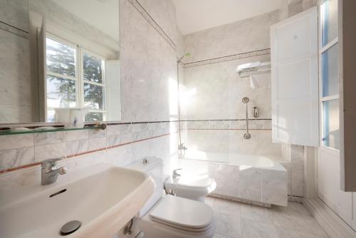 a white bathroom with a sink and a toilet at Miranda & Suizo in San Lorenzo de El Escorial