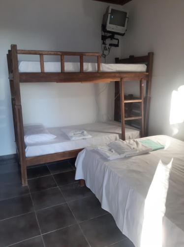 a room with two bunk beds and a tv at Pousada Hawai in Conde