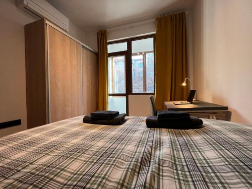 Schlafzimmer mit einem Bett, einem Schreibtisch und einem Fenster in der Unterkunft HOME 12 in Sofia