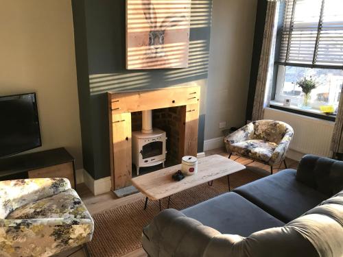 a living room with a couch and a fireplace at Heather Bank Cottage, Halifax. Yorkshire. HX2 7DD in Halifax