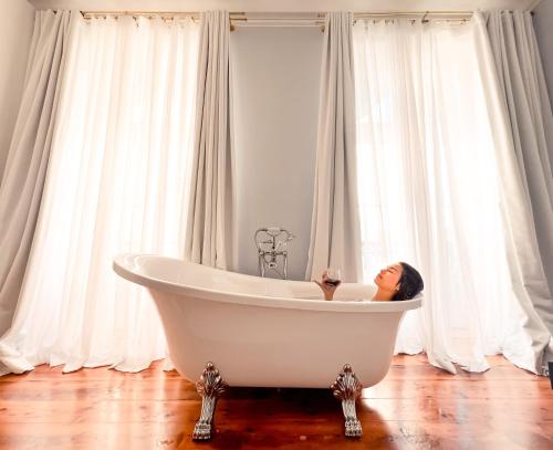 a woman sitting in a bath tub in a bathroom at Palácio do Visconde - The Coffee Experience in Lisbon