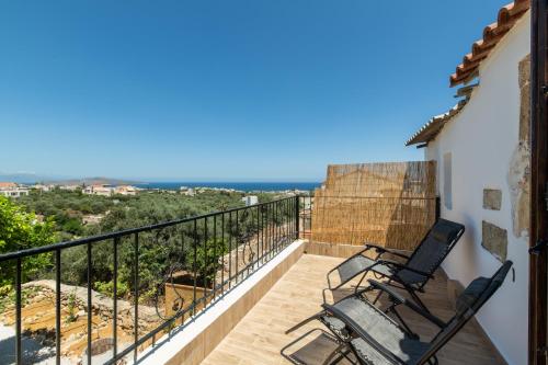 a balcony with two chairs and a view of the ocean at Beit Petra in Daratso