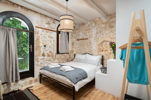 a bedroom with a bed and a stone wall at Beit Petra in Daratso