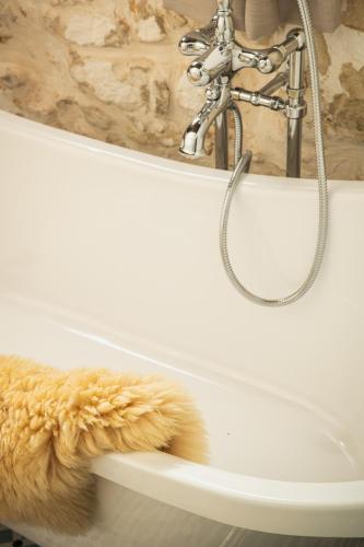 a white bath tub with a faucet and a towel at Beit Petra in Daratso