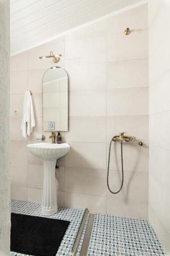 a white bathroom with a sink and a shower at Beit Petra in Daratso