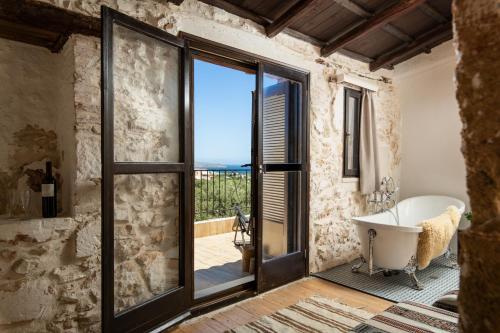 a bathroom with a tub and a view of the ocean at Beit Petra in Daratso