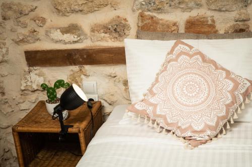 a bed with a pillow and a lamp on a table at Beit Petra in Daratso