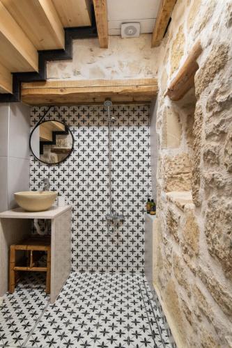 a bathroom with a shower with a sink and a tile floor at Beit Petra in Daratso