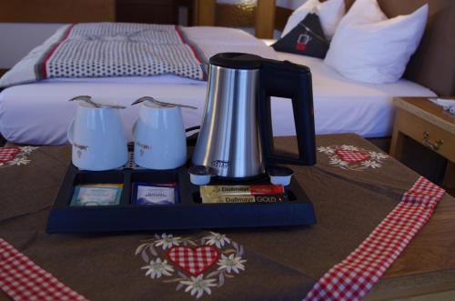 a coffee maker on a tray on a table next to a bed at Hotel Löwen in Reit im Winkl