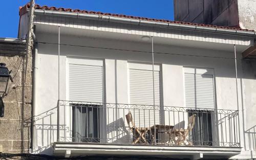 um cão sentado numa varanda de um edifício em A casa de Mateo em Ribadavia