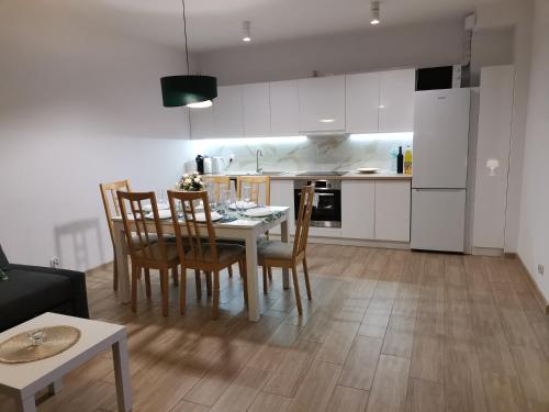 a kitchen and dining room with a table and chairs at APARTAMENT ADAMENTIS LUBAWA in Lubawa